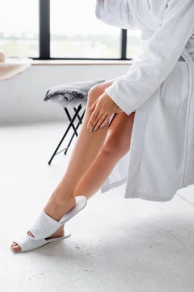 Vue dégagée de la femme en peignoir et pantoufles dans la salle de bain — Photo de stock