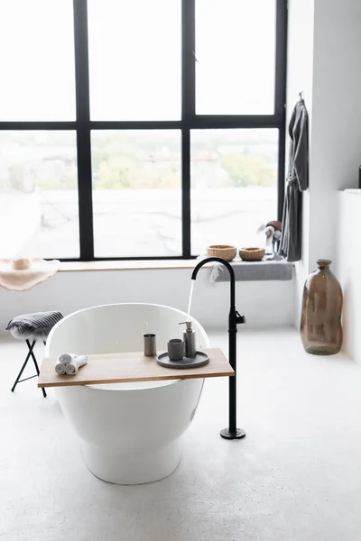Eau courante du robinet dans la baignoire blanche à la maison — Photo de stock