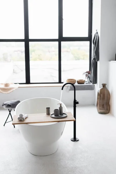 Flowing water from faucet in white bathtub at home — Stock Photo