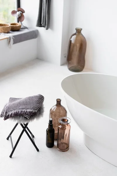 Decorative bottles near white bathtub at home — Stock Photo