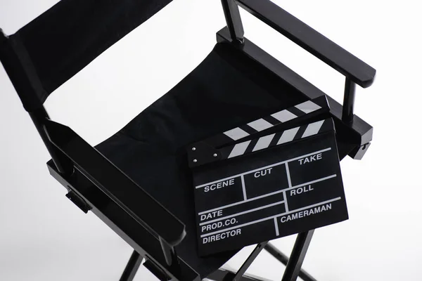 Vue grand angle du clapperboard sur chaise de réalisateur sur blanc, concept de cinéma — Photo de stock