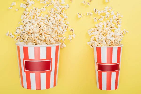 Vista superior de grandes y pequeños cubos con sabrosas palomitas de maíz en amarillo, concepto de cine - foto de stock