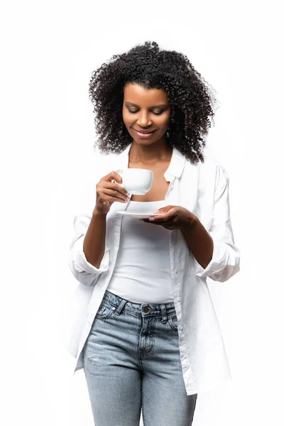 Smiling african american woman looking at cup of coffee isolated on white — Stock Photo