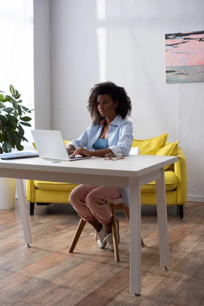 African american woman working on laptop in living room — Stock Photo