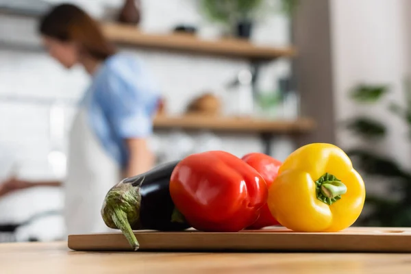 Close up view of fresh whole vegetables on cutting board in kitchen — Stock Photo