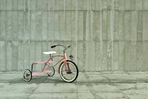 Beton üzerinde pembe üç tekerlekli bisiklet