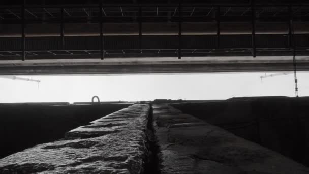 Старые поврежденные бетонные конструкции опорного моста или путепровода, с которого капает вода — стоковое видео