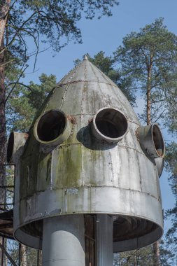 Abandoned old metal rocket mockup in the forest. Old Soviet model of a space rocket in the woods on a day.