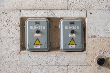 Kyiv, Ukrayna - Şubat 2021: Kabuk kayasıyla kaplı bir duvarda iki eski tarz Sovyet ışıklandırma levhası.