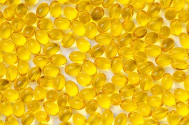 Beyaz arka planda sarı şeffaf haplar. D3 vitaminli haplar.