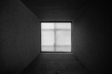 Çok uzun pencere pervazı olan karanlık odada soyut kare pencere.