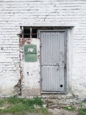 Old shabby metal doors made of garbage.