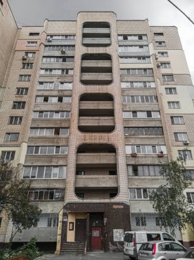 An old dirty residential multi-storey prefabricated concrete house in the style of brutalism in Eastern Europe. Kyiv, Ukraine - June 2021.
