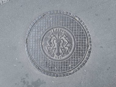 Eski Sovyet yeraltı tesisleri kapağı. Üzerinde telefon yazıları var. NKS (Halkın İletişim Komiseri). Kyiv, Ukrayna - Haziran 2021.