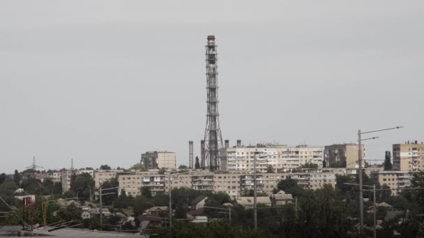 Высокий старый ржавый дымоход без дыма в городе в жаркий солнечный день с жилыми многоэтажными домами вокруг. — стоковое видео