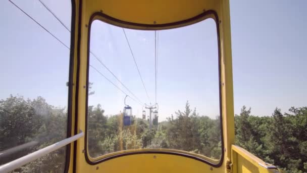公園の晴れた夏の日に古いケーブルカーの黄色のキャビンからの最初の人の眺め — ストック動画