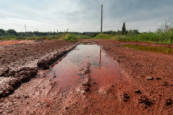 Pit with a puddle in red mud from iron ore.