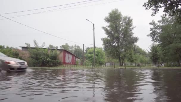 폭우가 쏟아진 도로에서 차가 달리고 있습니다. 우크라이나, 키예프 - 2021 년 6 월. — 비디오