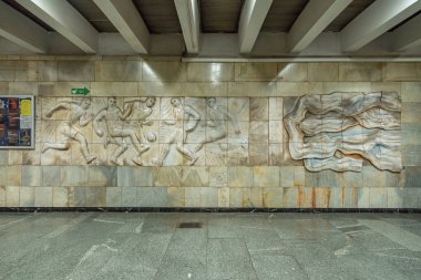 Heykeltıraş Oleksandr Milovzorov 'un 1980 Olimpiyat Oyunları için oluşturduğu Olimpiiska metro istasyonunun bilet gişesindeki atletlerle birlikte. Kyiv, Ukrayna 5 Temmuz 2025