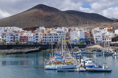 La Restinga, El Hierro / İspanya; 5 Nisan 2019: La Restinga limanı, şehir manzarası, volkan ve gri bulutlar arka planı, El Hierro, Kanarya adaları, İspanya