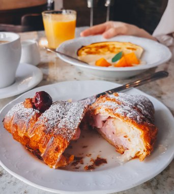 Bir kafede kahvaltı mermer bir masada, yakın çekim, atmosferik fotoğraf, yaşam tarzı, Paris, kruvasan ve peynirli kek, elleriyle fotoğraf.