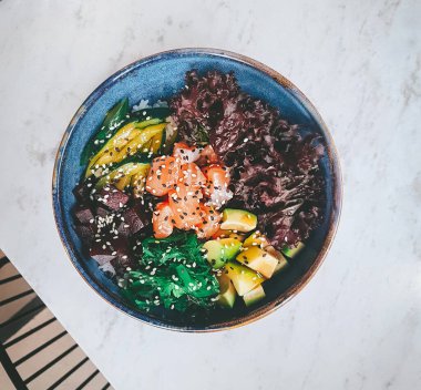 Poke with salmon and vegetables on marble background, Bowl lunch in cafe