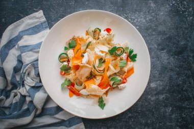 Peynirli sebze salatası, siyah üzerine beyaz tabak.