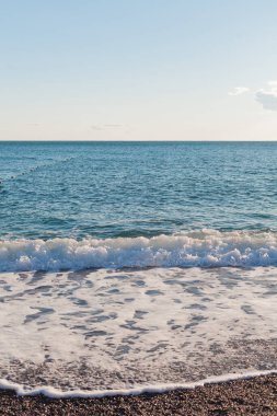 Deniz dalgaları kumlu kıyıya vuruyor