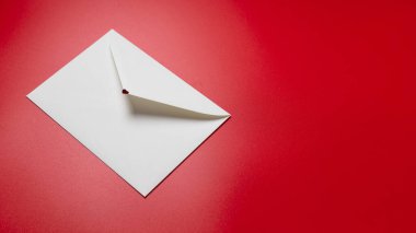 Kırmızı zemin üzerinde kalpler olan zarf