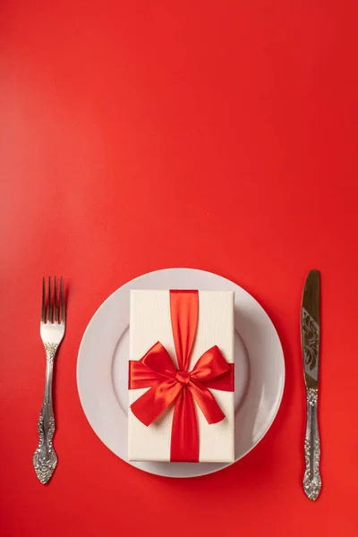 Gift on a serving plate on a red background