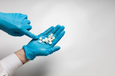 Eldivendeki bir elin içinde bir avuç hap var.