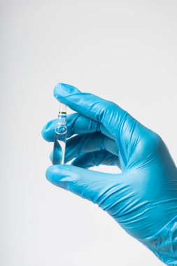 Aşı ampulü elinde tıbbi eldiven ile