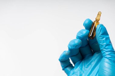 Aşı ampulü elinde tıbbi eldiven ile