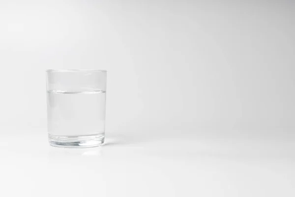Beyaz arkaplanda bir bardak su