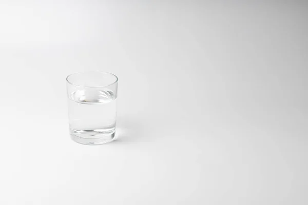 Beyaz arkaplanda bir bardak su
