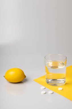 Lemon, bir bardak su ve ilaç.