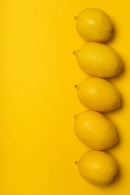 Sarı arka planda beş sarı limon