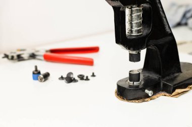 Beyaz arkaplandaki perçinlere perçinleme aygıtı