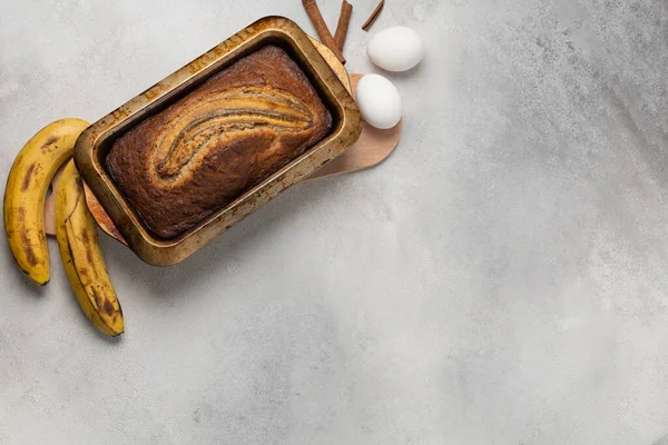 Dörtgen bir fırında taze muz ekmeği hazırlayın. İçindekiler hafif arkaplanda.