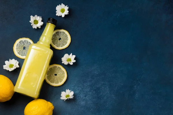 Bottiglia Limoncello Con Limoni Fiori Sfondo Blu Vista Dall Alto — Foto Stock