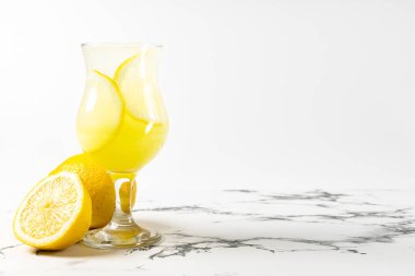 Limonçello kokteyli. Limonlu. Arka planda güzel bir bardak ve mermer masa.