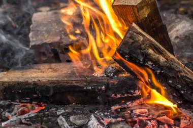 Parlak alevler. Ateş kıvılcımları. Yakacak odun. Ateşe körükle giden odunlar. Yanan kömürler. Noel arkaplanı. Açık ateşin sıcaklığı ve sıcaklığı. Ateş riski var. Ateşe karşı tehlikeli davranışlar.
