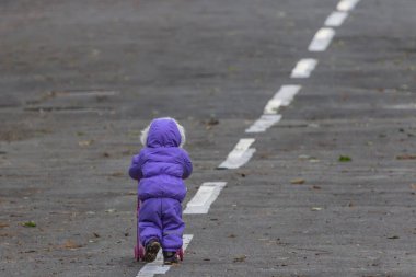 Çocuk yol boyunca yürüyor. Çocuk bakışı. Kendi yoluna git. Bebek arabalı kimliği belirsiz bir kız. Hayata giden yol. Küçük adam. Çocukların bağımsızlığı. Kış tulumları. Amaçlanan hedef.
