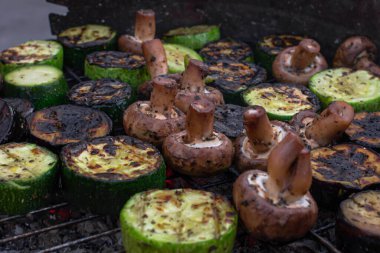 Izgara sebze. Piknikte ızgara yap. Açık ateşte yemek. Kabak, patlıcan ve mantar. Vejetaryen yemeği. Sağlıklı beslenme. Taze sebzeler tel askıda. Lezzetli ve sağlıklı yemekler..