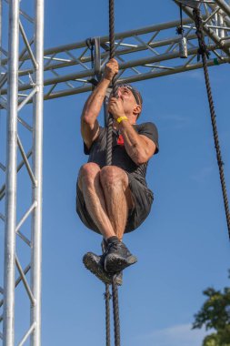 Engel parkuru. Bir adam maraton koşuyor. Spor müsabakaları. Ukrayna Sparta ırkı. İpe tırmanıyorum. Karnının üstünde sürünüyor. Kirli suda yüzmek. Fiziksel aktivite. Aktif boş zaman. Kendine meydan oku. Ukrayna sporları. Yardım amaçlı spor etkinliği. 