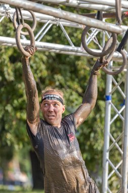 Engel parkuru. Bir adam maraton koşuyor. Spor müsabakaları. Ukrayna Sparta ırkı. İpe tırmanıyorum. Karnının üstünde sürünüyor. Kirli suda yüzmek. Fiziksel aktivite. Aktif boş zaman. Kendine meydan oku. Ukrayna sporları. Yardım amaçlı spor etkinliği. 