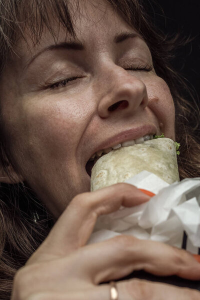 Человек кусает шаурму. Девушка ест фаст-фуд. Психическое здоровье. Пищевой промышленности. Жертва рекламы. Пьяный стресс. Неконтролируемое обжорство. Ешь с аппетитом. Текстура кожи. Человеческая жадность. Грех обжорства.