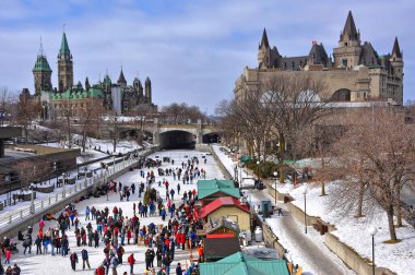 Ottawa, Kanada - 14 Şubat 2010: İnsanlar Kanada 'nın başkentinde düzenlenen Winterlude festivalini dünyanın en büyük açık hava buz pateni pistinde kutluyorlar. Arka planda Parlamento Binaları, R ve Laurier Şatosu var..