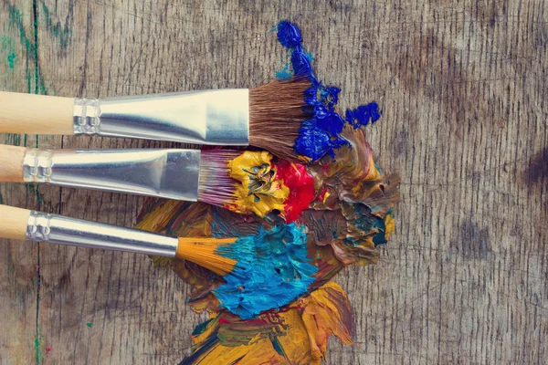 Pennelli artistici in una vernice colorata pronta per il lavoro — Foto Stock
