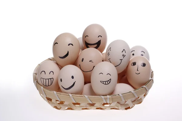 Яйца в бамбуковой корзине с улыбкой на лицах — стоковое фото
